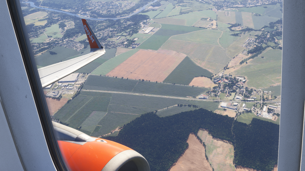 En vue SIM de l'A320 de Fenix ​​avec Winglets dans EasyJet Livery. Vue de fenêtres de passagers sur l'aile et le moteur à basse altitude au-dessus de la campagne. 