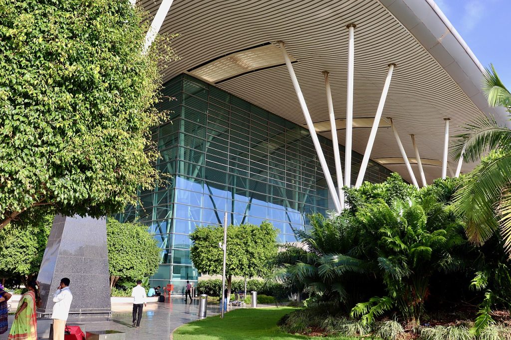 Image de la vie réelle de la vraie vie de la vie de Bengalaru du terminal de l'aéroport international de Kempegowda de Bengalaru 2 à l'extérieur, montrant une végétation luxuriante et des caractéristiques architecturales distinctives