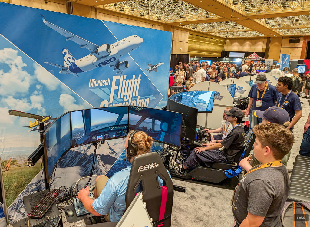 Les participants testent les configurations du simulateur de vol dans le hall d'exposition FlightSimExpo