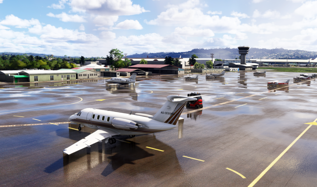 Aire de trafic de l'aéroport international Martinique Aimé Césaire avec avions stationnés sur un tarmac mouillé.